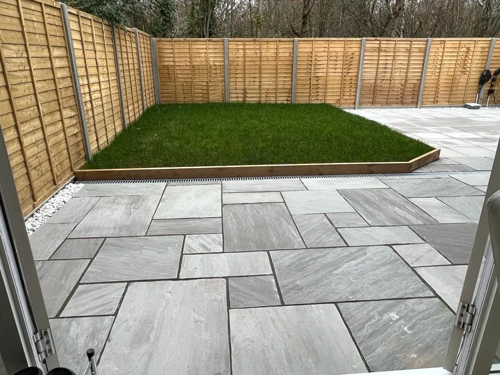 Finished grey sandstone patio with lawn - Reading